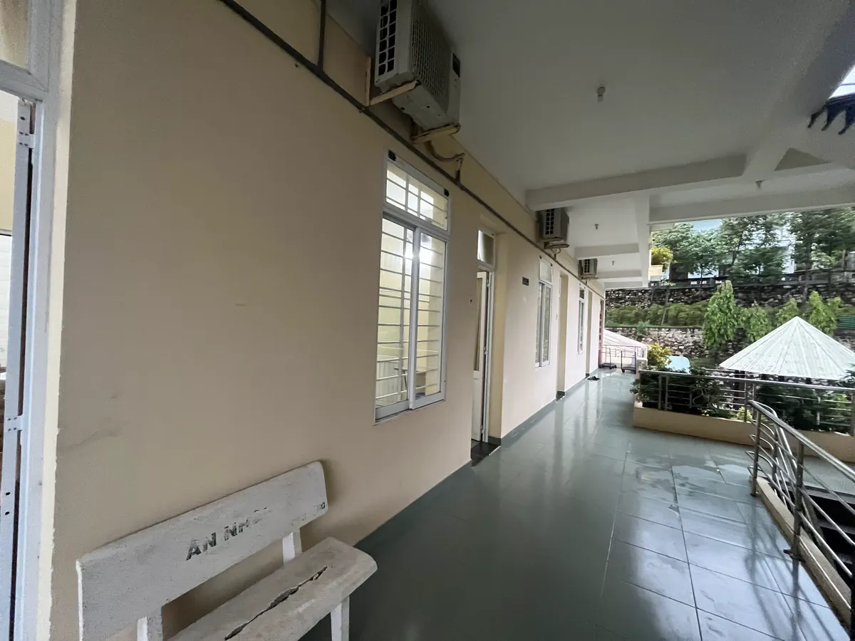 Hành lang tầng trên lát gạch, lan can inox nhìn ra sân