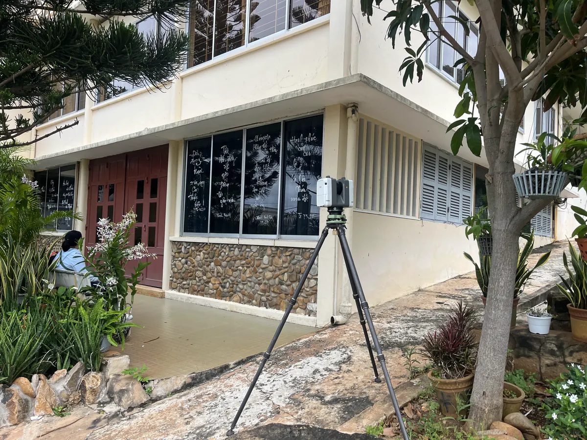 Trạm quét Leica RTC360 đặt sát chân khối nhà, giữa các bồn cây
