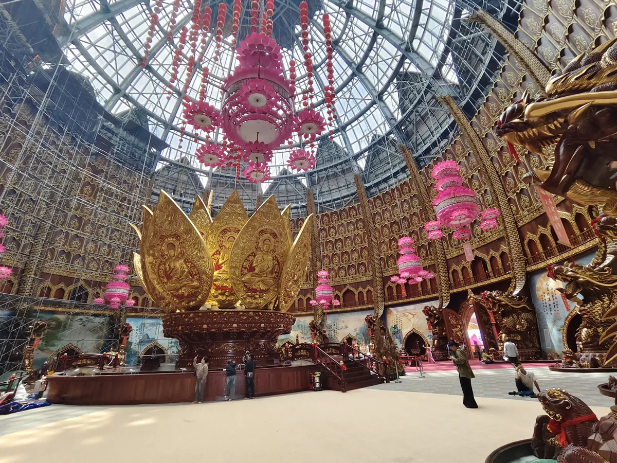 Interior of Liên Hoa Bảo Tháp with the golden lotus shrine, reliefs and lotus lanterns beneath the steel-framed dome